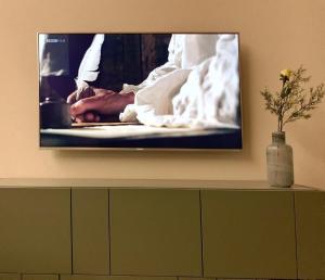 un televisor en una pared con una foto en él en Mountain 4U, en Meiringen