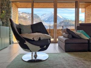una silla en la sala de estar con una ventana grande en Mountain 4U, en Meiringen