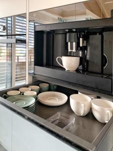 una cocina con tazones y platos blancos en una encimera en Mountain 4U, en Meiringen 14 fotos más