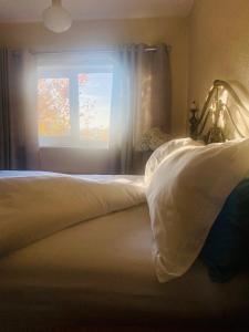 a bedroom with a bed with white sheets and a window at Lincoln Cathedral Retreat in Scampton