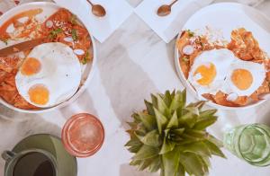 a table topped with two bowls of food with eggs at MARQUEE Playa Hotel in Playa del Carmen