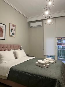 a bedroom with a large bed with two towels on it at KM Ethnikis Amynis B in Drama