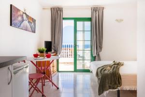 a room with a bed and a table and a door at Caleta Paraiso Sea View 137 in Costa de Antigua