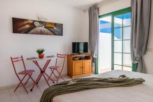 a bedroom with a bed and a table and chairs at Caleta Paraiso Sea View 137 in Costa de Antigua