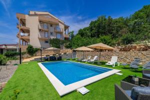 a villa with a swimming pool in front of a building at Apartments San in Dramalj