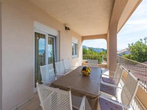 a porch with a table and chairs on a balcony at Apartments San in Dramalj