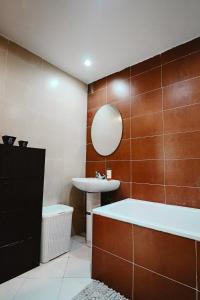 a bathroom with a tub and a sink and a mirror at L'Andalou -3 bedrooms with Parking in Downtown in Kenitra +15 photos