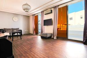 a living room with a piano and a television at L'Andalou -3 bedrooms with Parking in Downtown in Kenitra