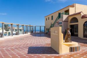 a statue of a cat sitting on a bench next to a building at Caleta Paraiso Sea View 137 in Costa de Antigua