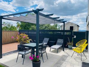 a patio with a table and chairs under a canopy at Élégant 2 pièces au calme, axe Metz-Luxembourg in La Celle-sous-Gouzon +16 photos