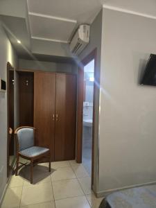 a room with a chair and a closet and a door at Hotel Rigolfo in Moncalieri