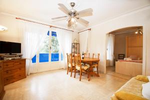 a living room with a dining room table and a television at Jardins Fleuris Standing Presta in Mandelieu-la-Napoule