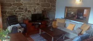 a living room with a couch and a mirror at Apartamento Carballo Do Xurès in Maus de Salas