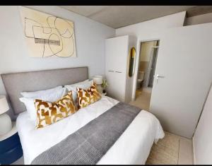 a bedroom with a large bed with brown and white pillows at Welcome Home in Cape Town