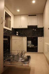 a kitchen with white cabinets and a dishwasher at Casa Uccello in Wildhaus