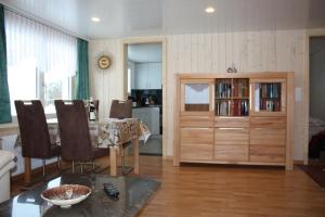 a living room with a dining table and a kitchen at Casa Uccello in Wildhaus