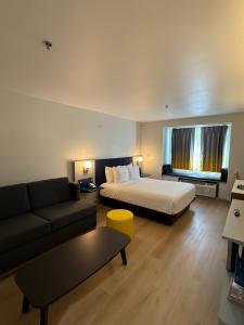 a hotel room with a bed and a couch at Microtel Inn and Suites Baton Rouge Airport in Baton Rouge +25 photos