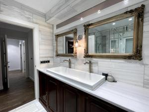 ein Badezimmer mit einem großen weißen Waschbecken und einem Spiegel in der Unterkunft Reno'd Heritage Camino Apartment in Nájera