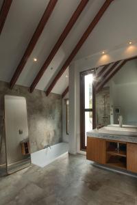 baño grande con bañera grande y lavamanos en Baan Chang Sanctuary, en Laguna Phuket