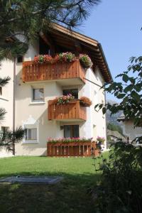 a building with flower boxes on the side of it at Aivla in Celerina
