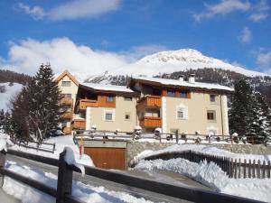 a house in the snow in front of a mountain at Aivla in Celerina