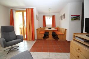 a living room with a table and a chair at Aivla in Celerina