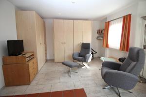 a living room with two chairs and a television at Aivla in Celerina