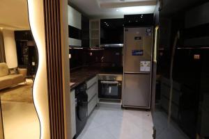 Il comprend une cuisine équipée d'un réfrigérateur et d'une cuisinière en acier inoxydable. dans l'établissement Appartement calme et luxueux, à Hydra