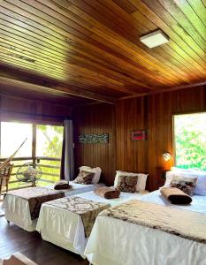 three beds in a room with a wooden ceiling at Bela Vista Lodge in Novo Airão