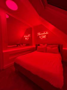 a red bedroom with a bed with red lights at Villa Signature in Oberhausbergen