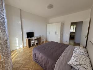 a bedroom with a bed and a desk with a computer at Appartamento DIMORA GUIDI 3 camere 2 bagni URBINO in Urbino