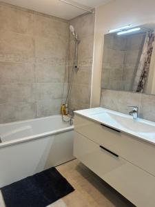 Pleumeur-GautierにあるDomaine du colombier - Kerveganの浴槽、洗面台、シャワーを備えたバスルーム