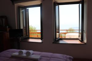 een slaapkamer met 2 ramen en een bed met 2 handdoeken bij Pelion country house in Volos