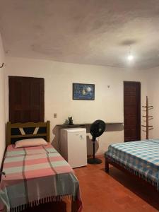 a bedroom with two beds and a desk and a chair at Casa Maria Bonita in Aracati