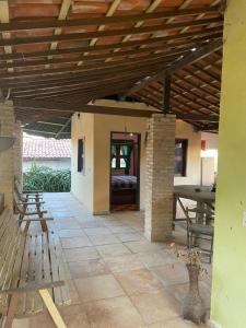 a patio with a table and chairs and a wooden ceiling at Casa Maria Bonita in Aracati