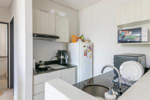 a kitchen with a sink and a refrigerator at Calido 1BR Dpto, a minutos del Aeropuerto in Asuncion