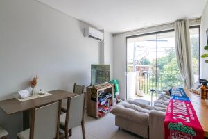 a living room with a table and a couch and a dining room at Calido 1BR Dpto, a minutos del Aeropuerto in Asuncion +2 photos