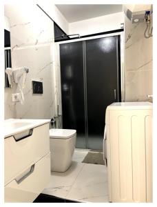 a bathroom with a toilet and a glass shower at Calipso Suite Room in Pozzallo