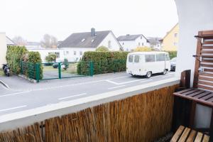 a white van parked on a street next to a fence at raum life - Ferienwohnung Straubing #1 in Straubing