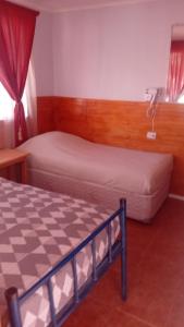 a hotel room with two beds and a window at Hostal Ribera de Quitor in San Pedro de Atacama