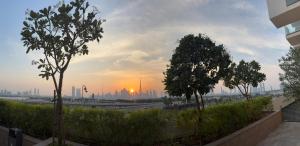 een uitzicht op de skyline van de stad met bomen op de voorgrond bij Deluxe studio water front in Dubai