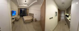 een gang die leidt naar een kamer met een bed en een televisie bij Deluxe studio water front in Dubai