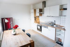 a kitchen with a wooden table with a vase of flowers at raum life - Ferienwohnung Straubing #1 in Straubing
