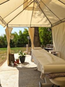 Dos camas bajo una sombrilla en un patio en Le Calle, en Iglesias