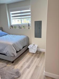 a bedroom with a bed and a window at Prince George Cozy Suite in Prince George