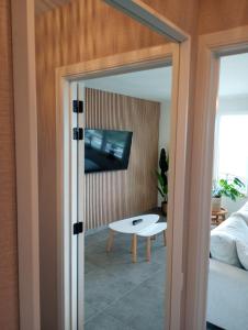 una sala de estar con un televisor y una mesa en Duinzicht, en Westende-Bad