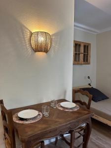 een eettafel met twee borden en glazen erop bij Studio Le Clocher in Saint-Étienne-de-Tinée