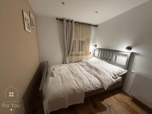 ビストシツァ・クウォツカにあるApartamenty For Youの白いシーツと窓のあるベッドのある寝室 +3枚の写真