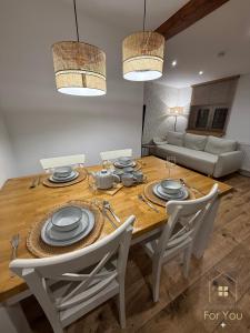 ビストシツァ・クウォツカにあるApartamenty For Youの木製のテーブルと椅子のあるダイニングルーム