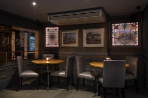 ボストンにあるTwenty Hotel and Barのテーブルと椅子が2つあり、ステンドグラスの窓があるレストラン